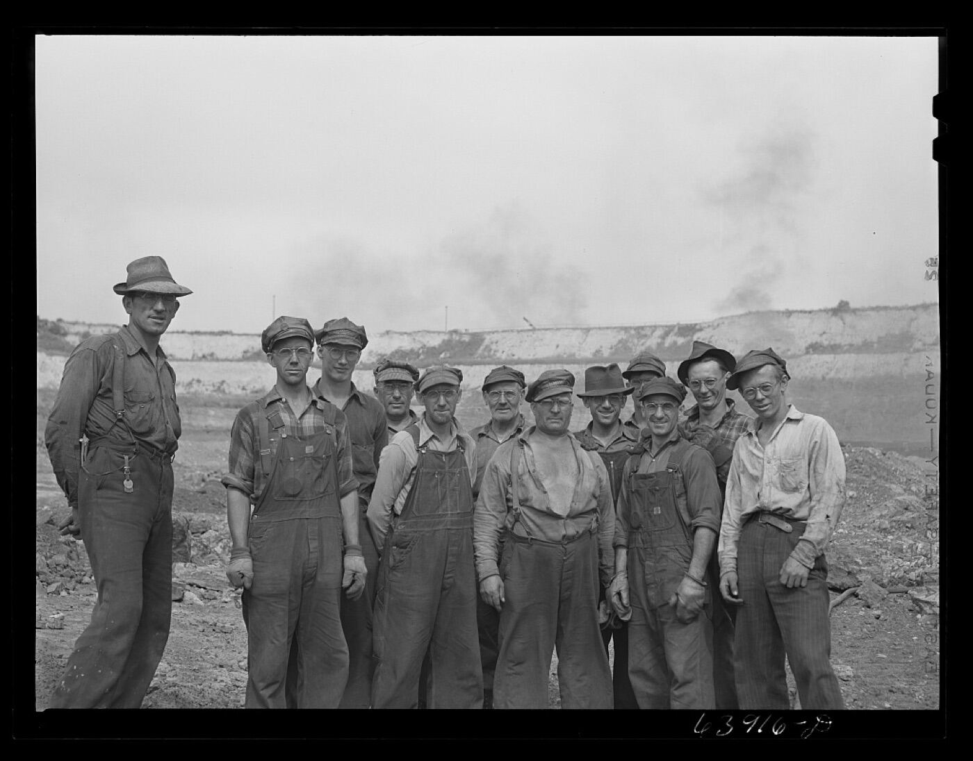 Mining crew standing beside drilling equipment.